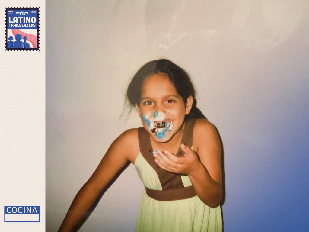 Henna Sharee, part of Latino Trailblazers, as a young child similng at the camera, with birthday cake on her nose. Photo courtsey of Henna Sharee